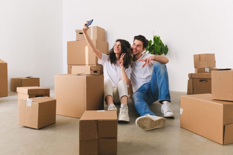 Couple unpacking moving boxes with a first apartment checklist